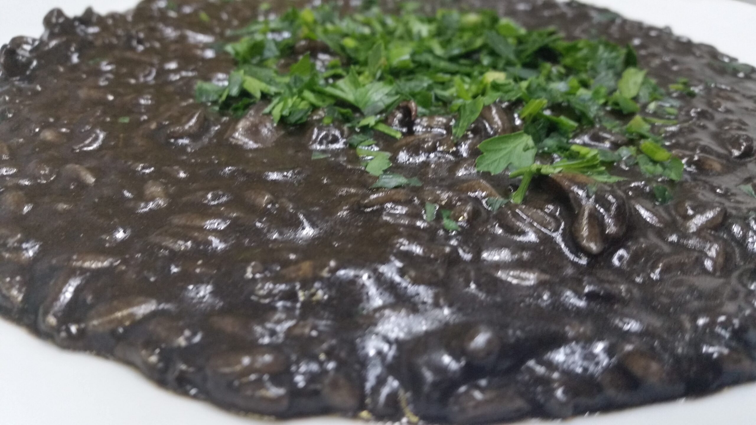 Risotto al nero di seppia con prezzemolo tritato