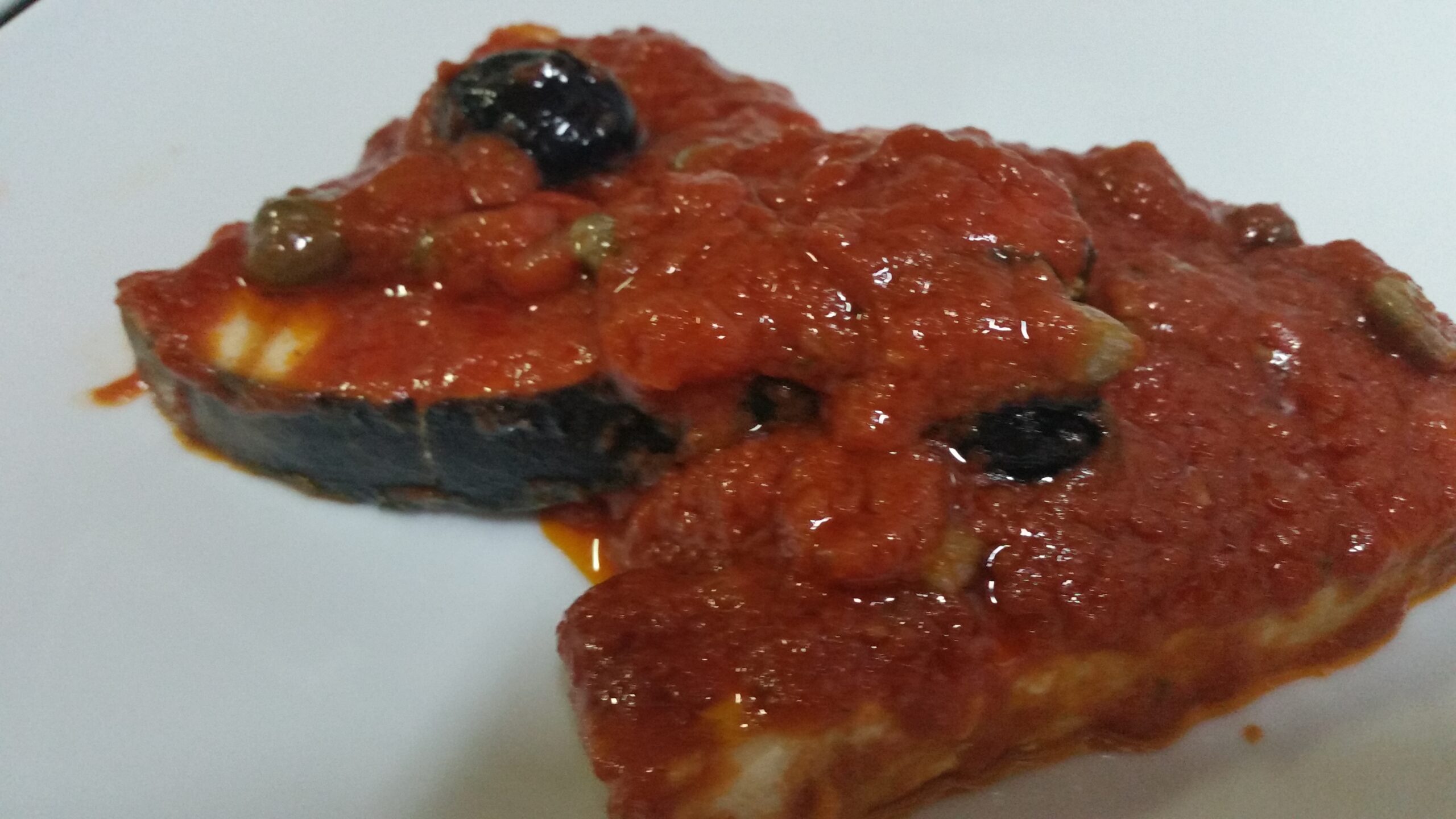 Tranci di pesce spada in salsa di pomodoro con capperi e olive nere