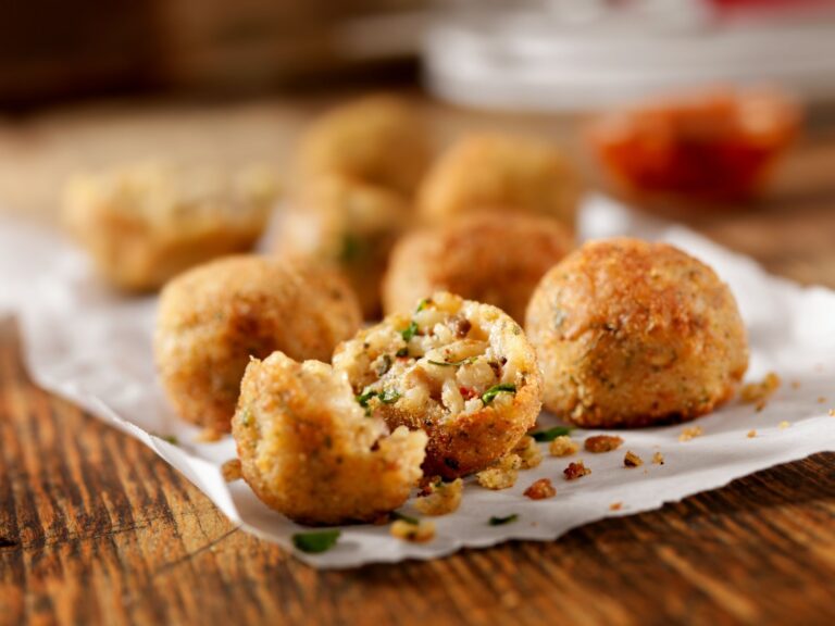 Arancini al tonno e cipolla, uno aperto per mostrare il ripieno