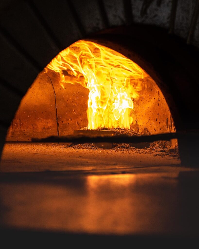 Forno a legna acceso con fiamma viva, pronto per cuocere il pane
