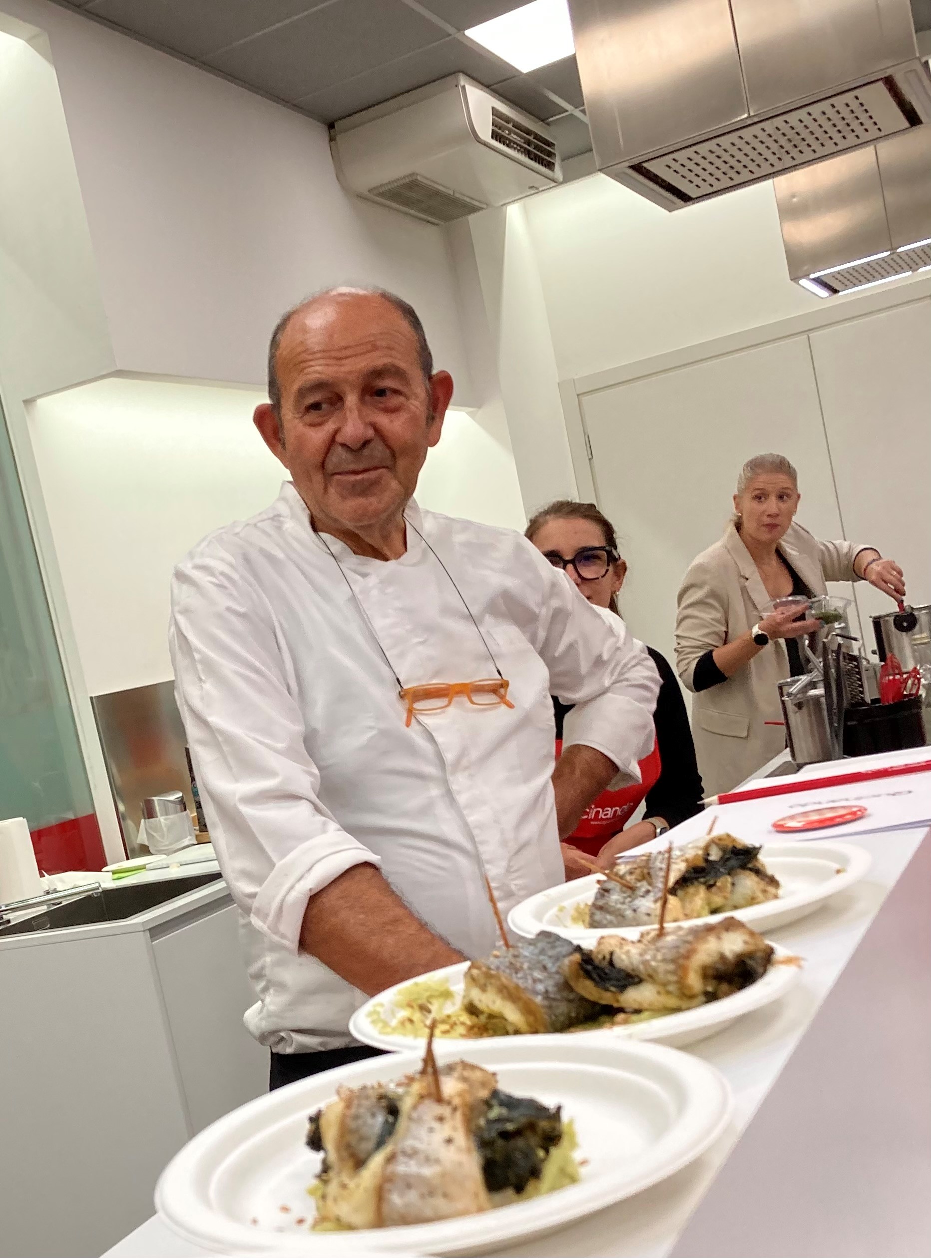 Salvo Nicastro, chef, alla scuola di cucina Qucinando con i piatti di pesce preparati durante un team building