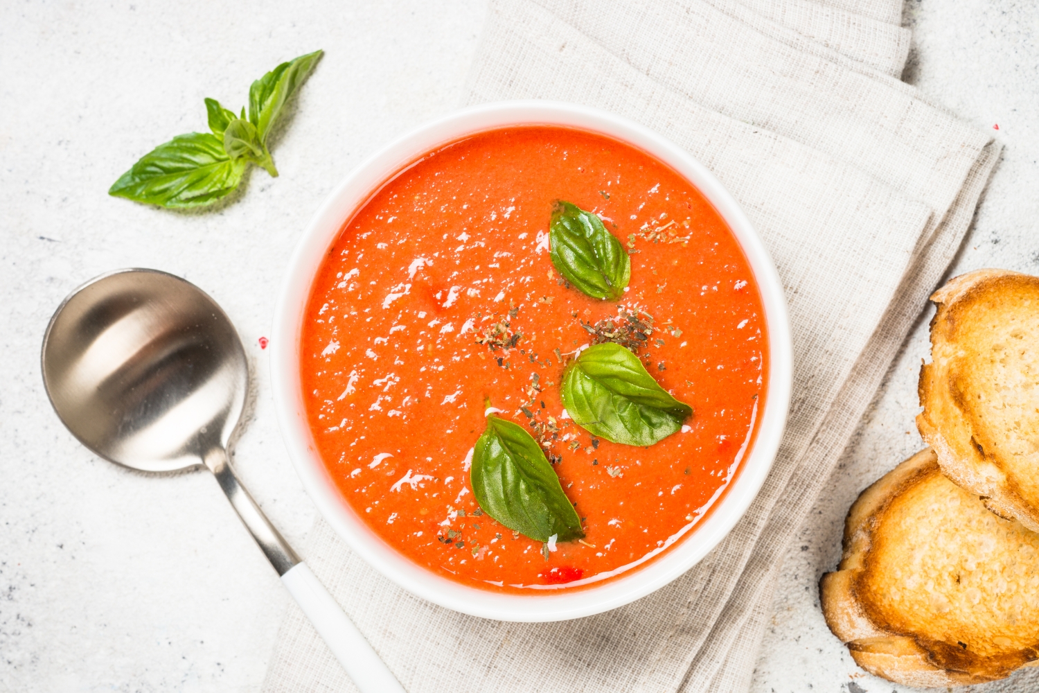 Zuppa di pomodoro con foglie di basilico e fette di pane tostato